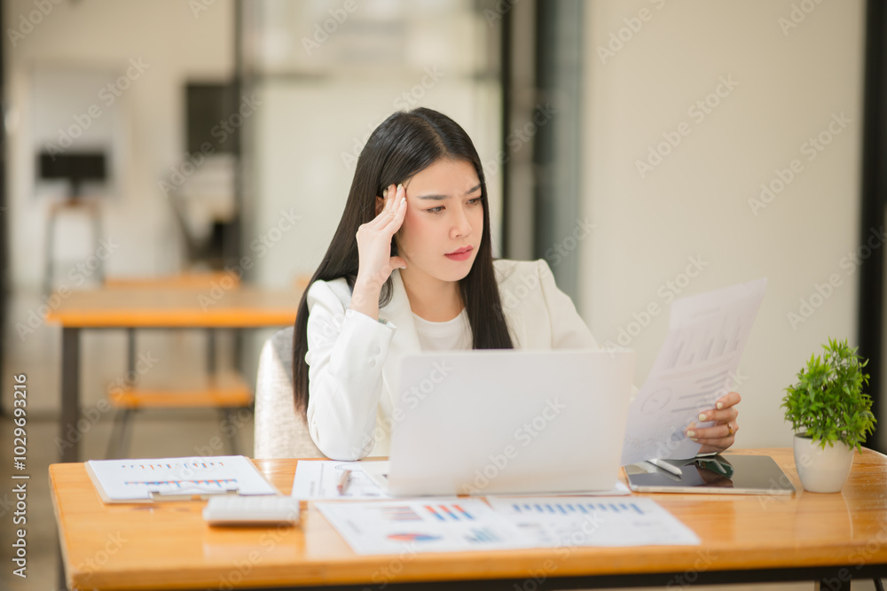 Asian business woman Stressed out and headache with paperwork at the office Asian business woman Stressed out and headache with paperwork at the office