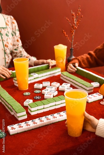 Woman in cheongsam playing mahjong(majiang), close-up, traditional Chinese mind game(Translation: mahjong terms, east, west, south, north, middle, fortune) photo