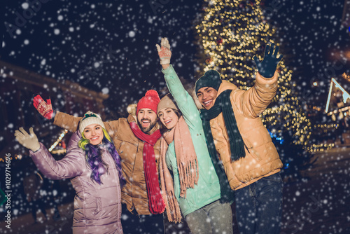 Portrait of group funny excited buddies arms waving hi have good mood x-mas evening lights outdoors photo