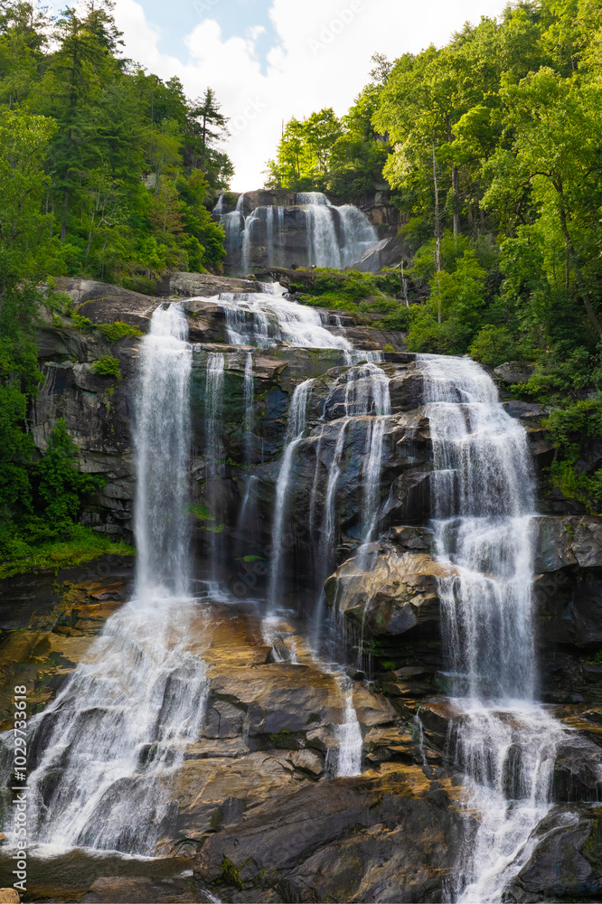 Obraz premium Whitewater Falls in Nantahala National Forest, North Carolina, USA. Beautiful landscape of high waterfall with falling down clear water from rocky boulders between green lush woods