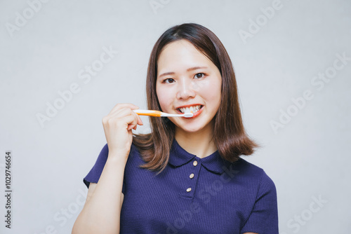 歯ブラシで歯を磨く女性 A woman brushing her teeth with a toothbrush