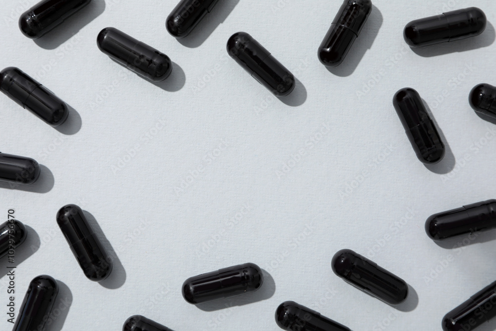 Activated carbon in the form of tablets, on a light background. Activated carbon in the form of tablets, on a light background.