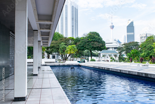 Photography The reflecting pool at masjid negara mosque with the kuala lumpur skyline in the