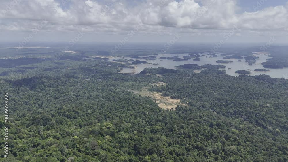 Drone flies from Brownsberg Hill toward valley with forested islands in lake and gold mines along the way in Suriname Drone flies from Brownsberg Hill toward valley with forested islands in lake and gold mines along the way in Suriname