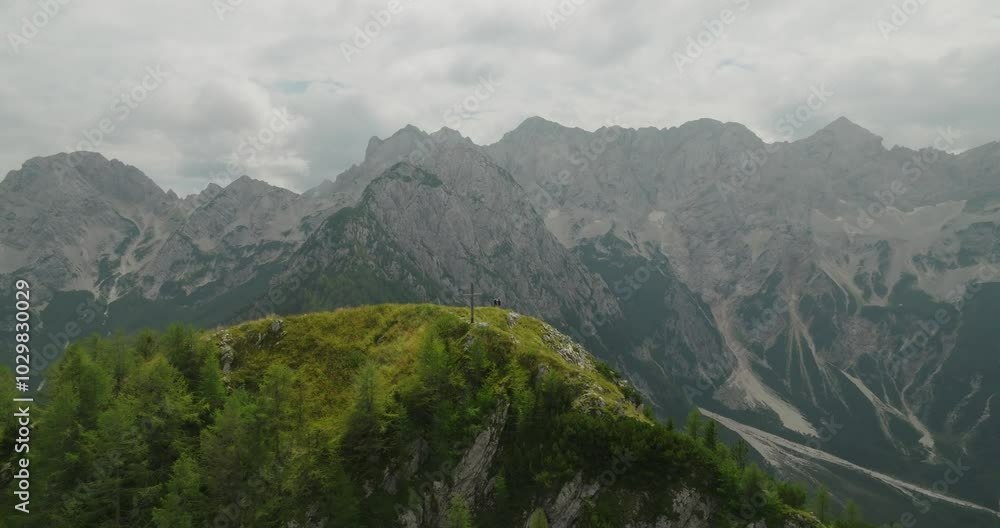 Couple enjoys stunning mountain views while hiking on Goli Peak in Slovenia under cloudy skies Couple enjoys stunning mountain views while hiking on Goli Peak in Slovenia under cloudy skies