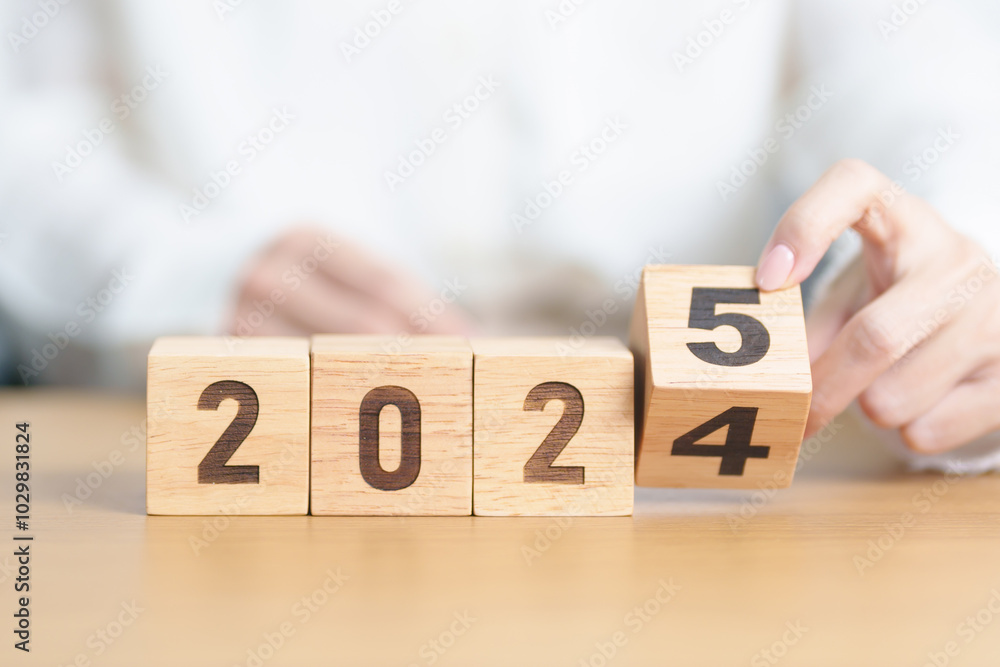 Naklejka premium 2024 change to 2025 year block on table. goal, Resolution, strategy, plan, start, budget, mission, action, motivation and New Year concepts
