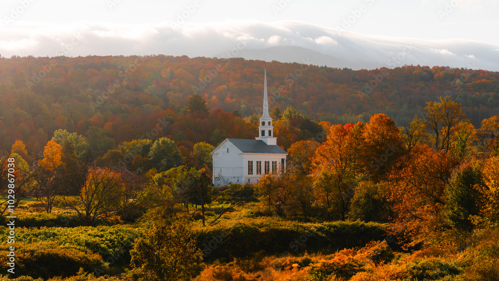 Naklejka premium Stowe Vermont New England Small Town Church Steeple Fall Foliage Autumn Season. Travel Tourism in October USA Colorful Forest Main Street Visit Travel
