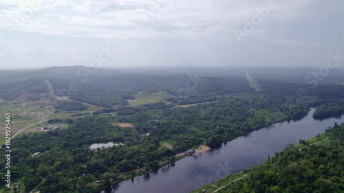 Flyover Amazone rainforest and river, Suriname, with road in the distance photo