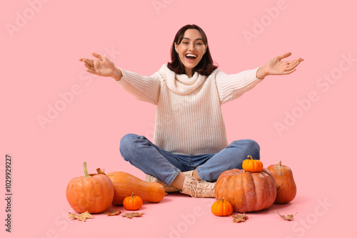 Young woman with pumpkins a...