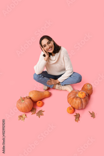 Young woman with pumpkins a...