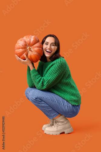 Young woman with pumpkin on...