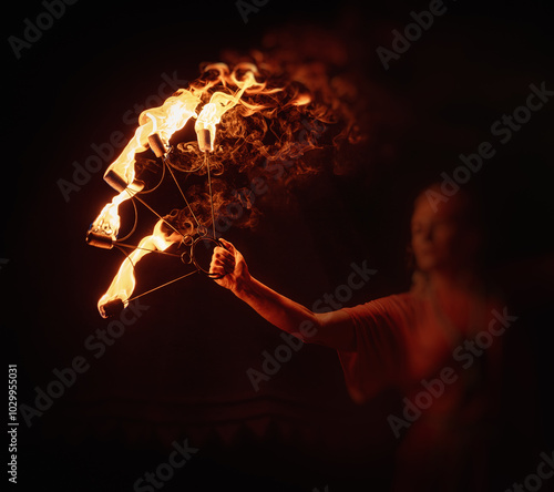 An enchanting fire dancer beautifully showcases her talent with mesmerizing flames during a performance.