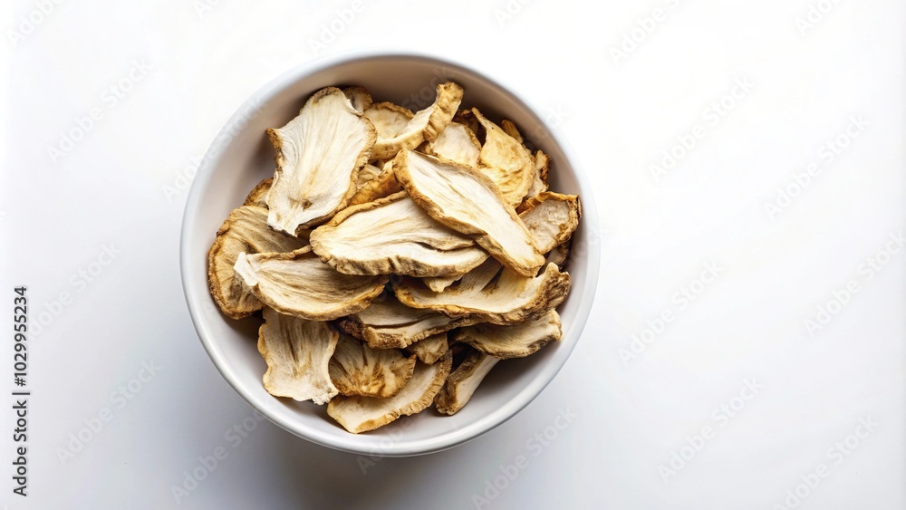Sliced Angelica root in white bowl from above against white background Sliced Angelica root in white bowl from above against white background
