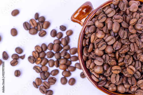 Top View of Coffee Beans in a Brown Bowl with Surrounding Beans photo