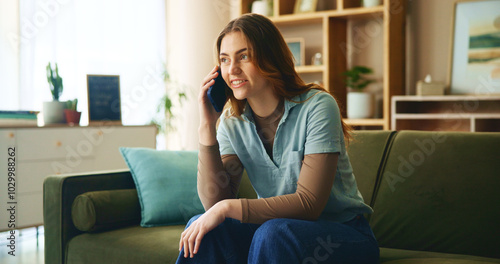 House, phone call and woman on sofa, smile and relax with discussion, talking and mobile user. Apartment, happy person and girl with smartphone, connection and chatting to contact and communication