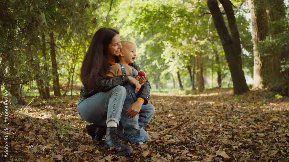 Warm afternoon sunlight bathes a mother and child, their connection evident in their shared gaze. A tender moment in the park, where a child's wonder meets a mother's love. Sunlight streams through Warm afternoon sunlight bathes a mother and child, their connection evident in their shared gaze. A tender moment in the park, where a child's wonder meets a mother's love. Sunlight streams through