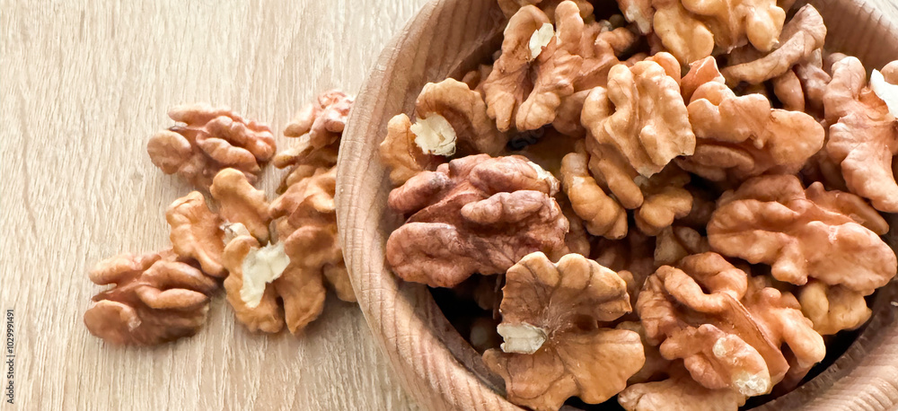 Walnut kernel halves, in a wooden bowl. Close-up, from above on colored background. Healthy eating Walnut concept. Super foods with copy space. Walnut kernel halves, in a wooden bowl. Close-up, from above on colored background. Healthy eating Walnut concept. Super foods with copy space.