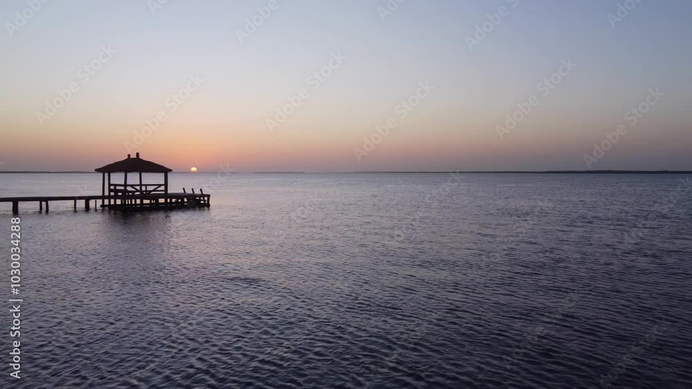 Idyllic walk with wooden planks and a hut on a lake in Senegal at sunset Idyllic walk with wooden planks and a hut on a lake in Senegal at sunset