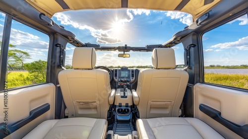 Rear view of a SUV's interior with two seats facing a sunny sky and a field view photo