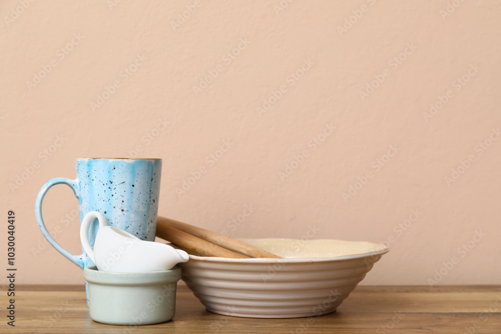 Clean dishes on table near beige wall Clean dishes on table near beige wall
