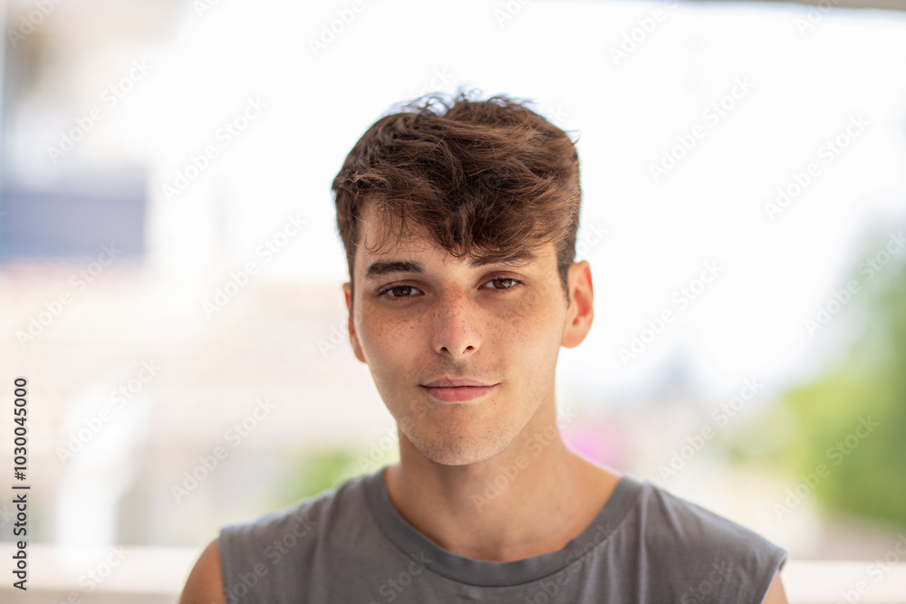 Portrait of handsome young man sitting on sofa and looking at camera and smiling Portrait of handsome young man sitting on sofa and looking at camera and smiling