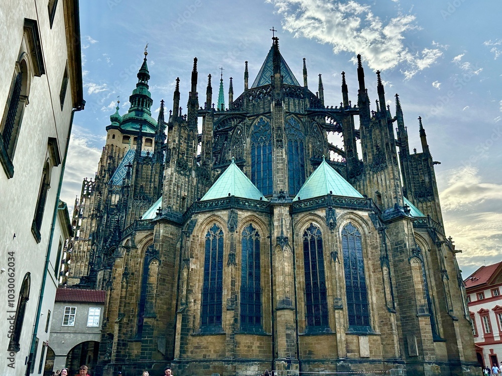 Fototapeta premium This photo captures the architectural charm and landscape of Prague’s medieval cityscape bathed in the warm glow of a summer sunset, highlighting its timeless beauty.