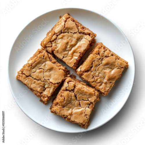 Four homemade blondie bars on white plate with cracked golden tops. dessert concept.