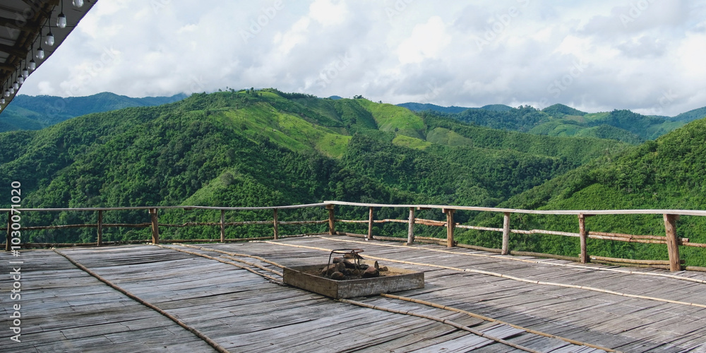 Obraz premium Landscape image of mountain view from wooden balcony with bonfire