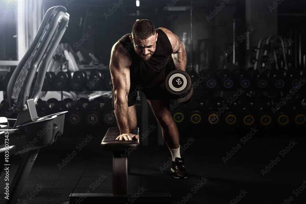 Muscular man having training with weights. Brutal strong athletic men pumping up muscles workout. Concept bodybuilder doing exercises in gym.