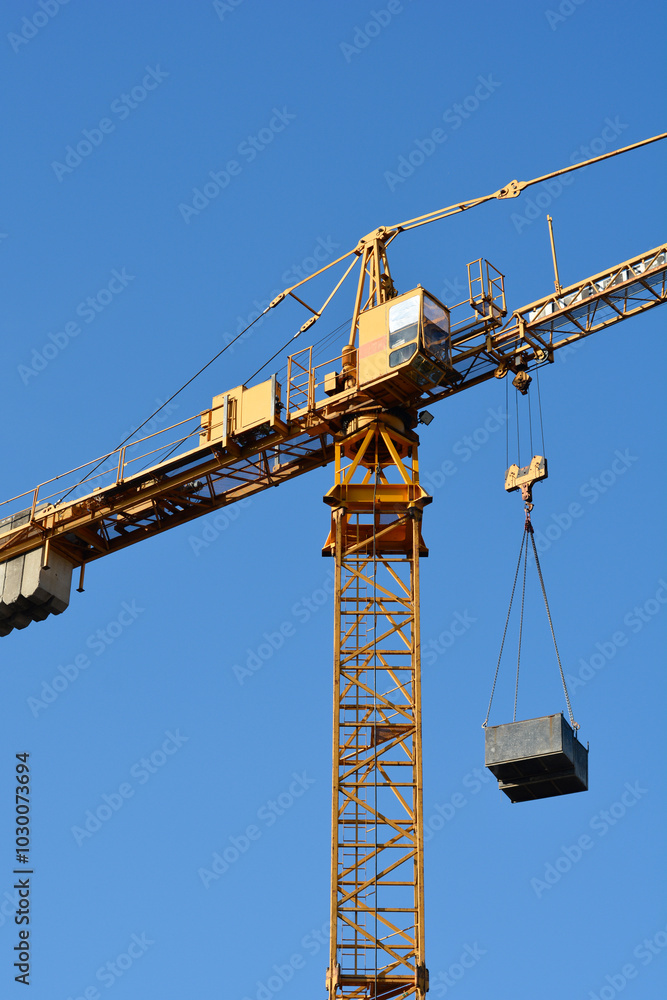 Detail of a construction tower crane against blue sky Detail of a construction tower crane against blue sky