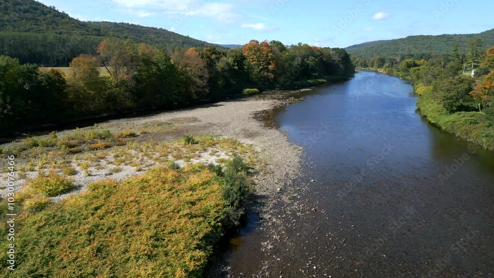 Drone curves around riverine forest edge over pebble rocks in Mohawk Trail by Deerfield River in Western Massachusetts New England USA Drone curves around riverine forest edge over pebble rocks in Mohawk Trail by Deerfield River in Western Massachusetts New England USA