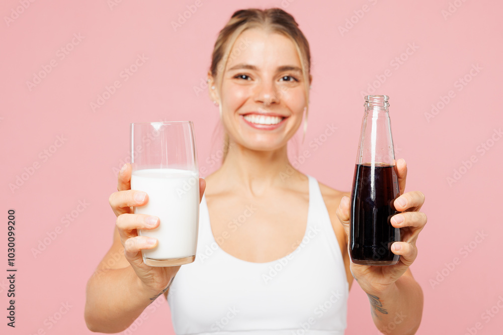 Close up young woman wear white top casual clothes choose hold glass of milk, bottle of soda pop isolated on plain pastel pink background. Proper nutrition healthy fast food unhealthy choice concept.