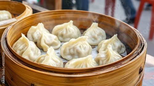 Steaming hot dumplings on a bamboo basket, crowded street