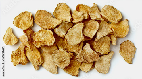 A collection of dried angelica root slices with their rough, woody texture, laid out on a white background