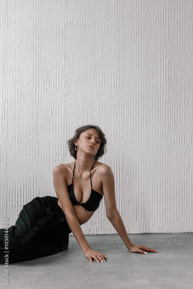 Model crouches elegantly on a smooth surface, showcasing her clothing and striking a confident pose while emphasizing her natural beauty in a modern, stylish environment Model crouches elegantly on a smooth surface, showcasing her clothing and striking a confident pose while emphasizing her natural beauty in a modern, stylish environment