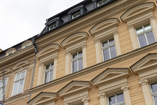 A large and impressive building that features a significant number of windows, as well as several elegant columns adorning its structure