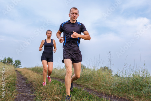 Two runners enjoying a morning jog along a scenic path in a green landscape