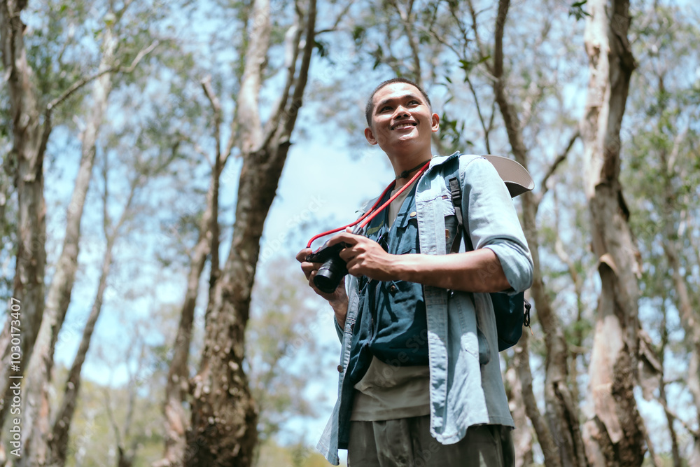 A tourist with a camera travels in the forest. Travel concept A tourist with a camera travels in the forest. Travel concept