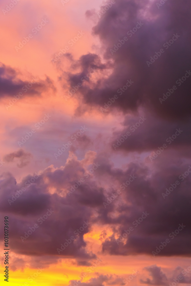 Fototapeta premium Stunning sunset with vivid pink and orange hues illuminating dramatic cloud formations.
