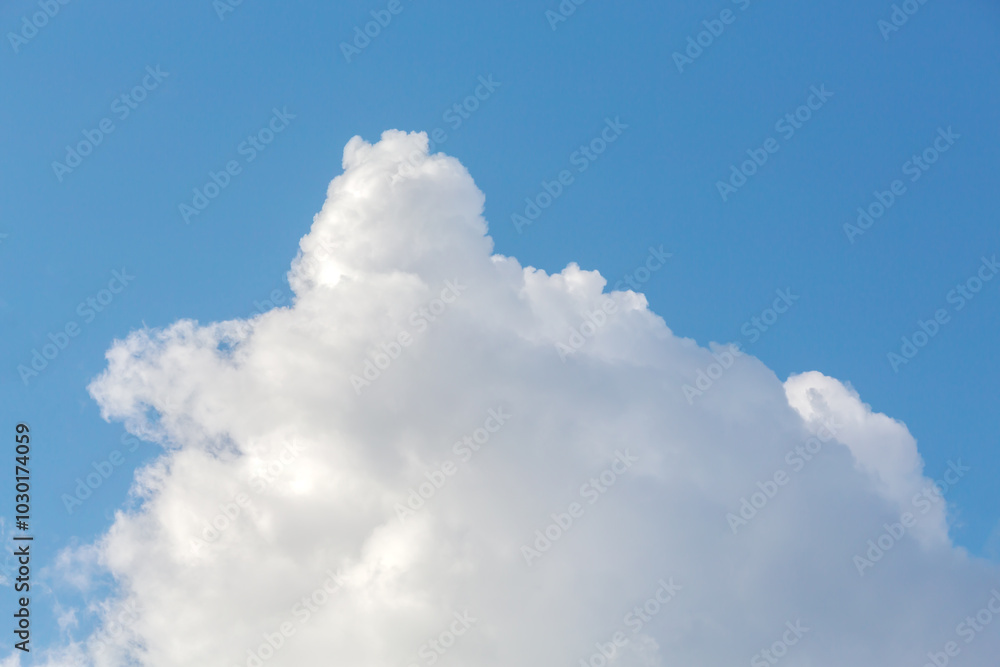 Single large white cloud against a bright blue sky, creating a simple, airy, and peaceful atmosphere, ideal for backgrounds and nature themes Single large white cloud against a bright blue sky, creating a simple, airy, and peaceful atmosphere, ideal for backgrounds and nature themes