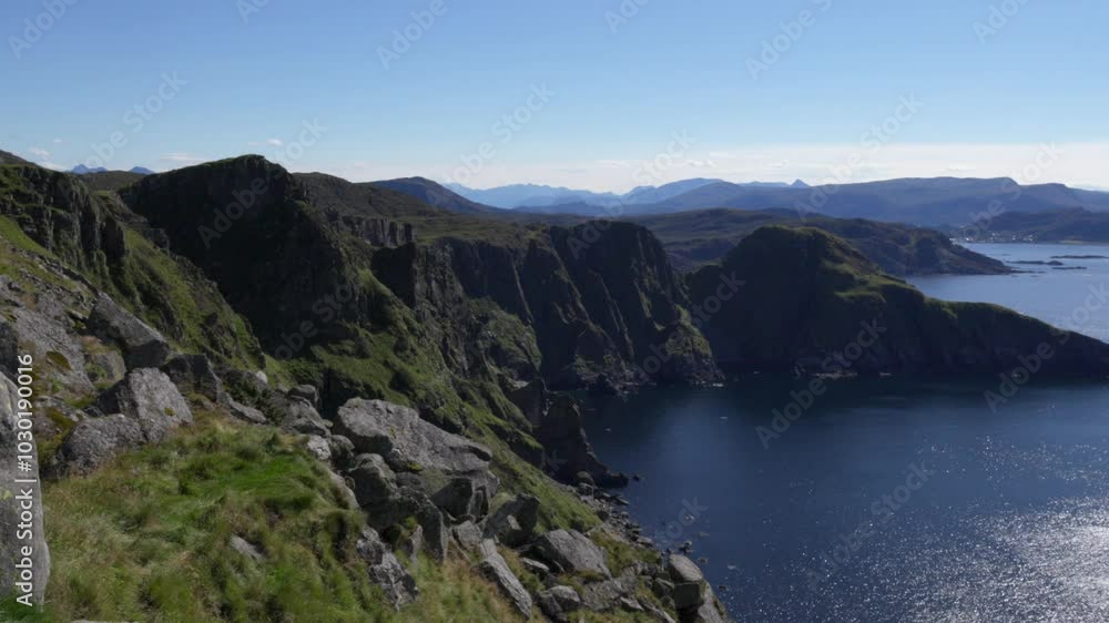 Scenic view of rocky cliffs overlooking sea on a sunny day with blue sky on Runde Island in Norway Scenic view of rocky cliffs overlooking sea on a sunny day with blue sky on Runde Island in Norway