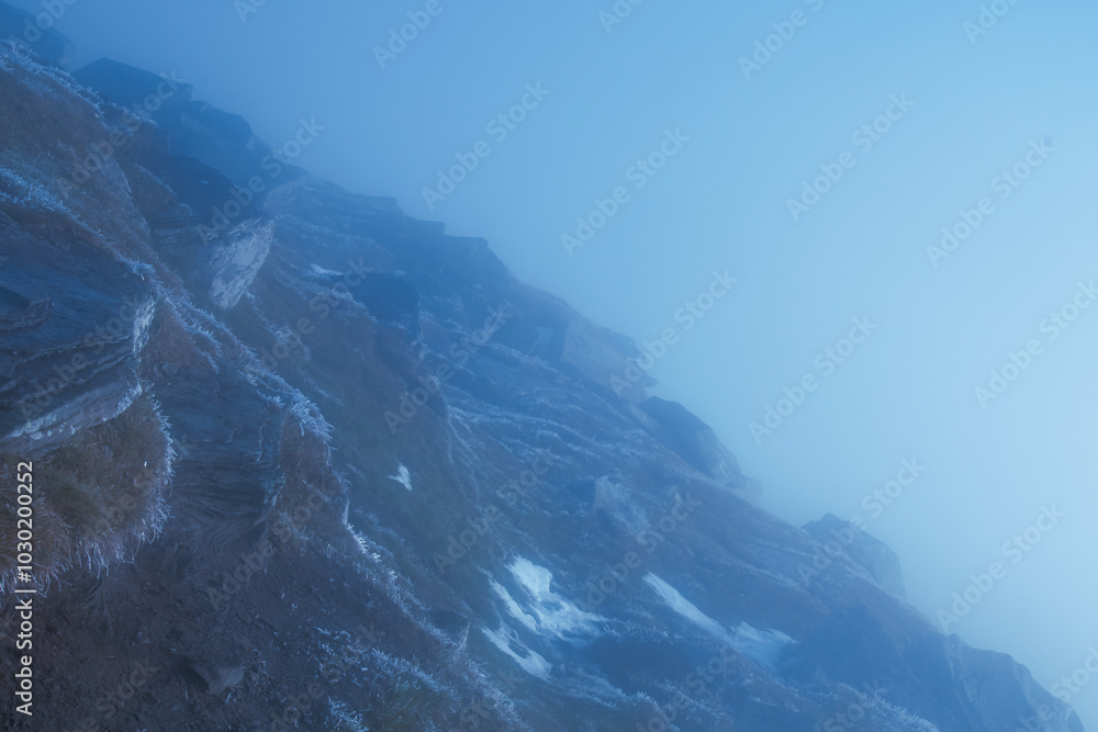 Fog and clouds in the mountains. Mountain landscape with clouds and nebula. Horizontal image.
