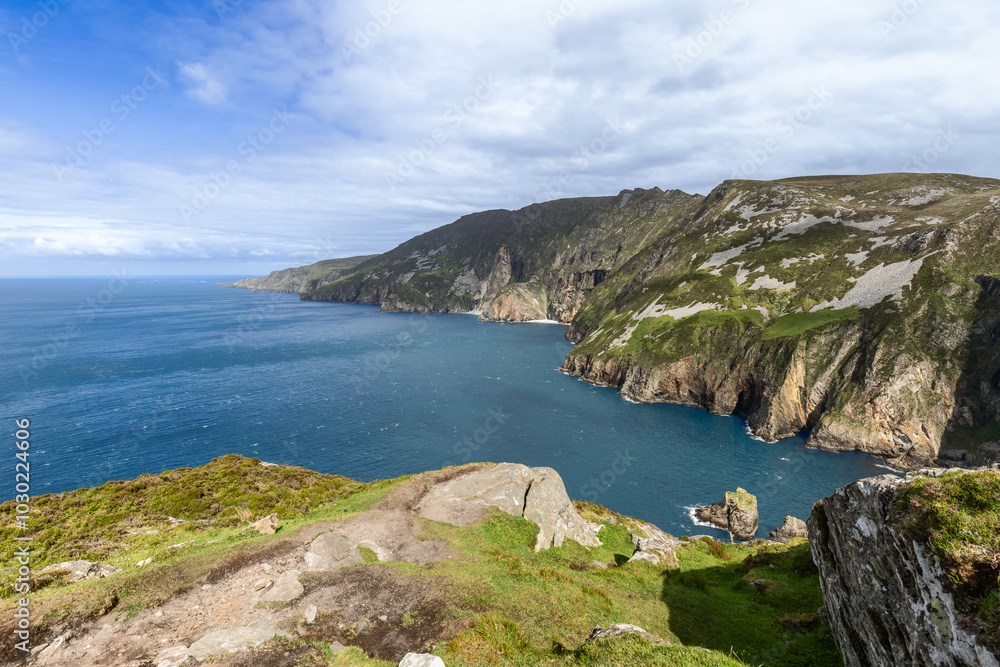 Fototapeta premium Expansive view of Slieve League cliffs in Ireland, with sheer rock faces dropping into the deep blue Atlantic, under a bright sky