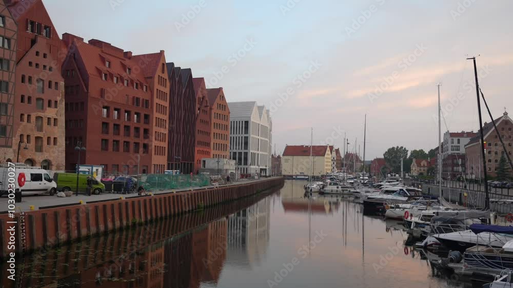 Apartments along Motlawa river in Gdansk. Canal with boats on a calm morning Apartments along Motlawa river in Gdansk. Canal with boats on a calm morning