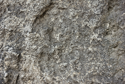 Texture of stone surface. Close-up of grey surface of hewn stone photo