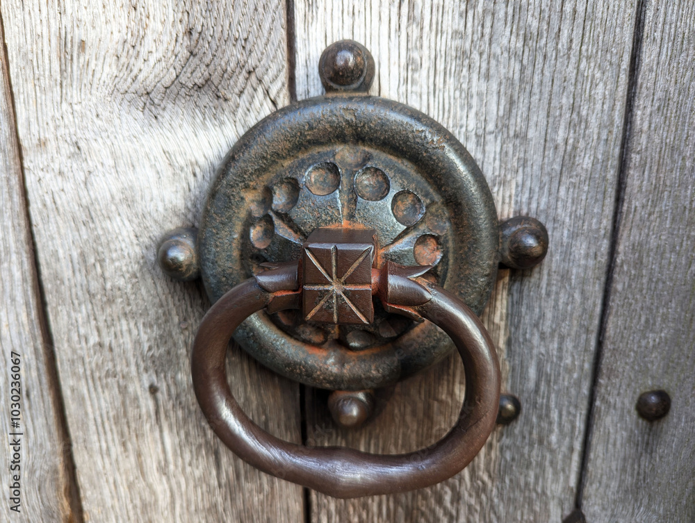 A close up view of a large iron door knocker and handle on an ancient church in Herefordshire, England. A close up view of a large iron door knocker and handle on an ancient church in Herefordshire, England.