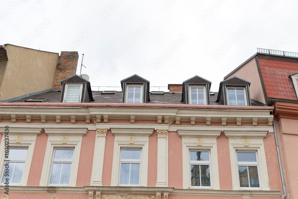 Obraz premium A tall and expansive building that features a large number of windows and has a noticeable chimney situated on the roof area