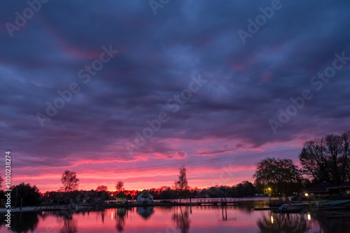 A breathtaking and enchanting sunset casts vibrant and captivating colors over a serene and peaceful lake landscape