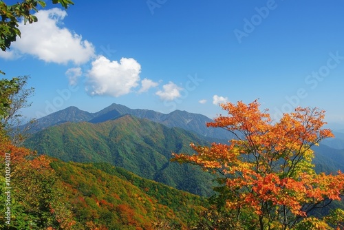 Autumn colors paint the mountains under a bright blue sky in a serene landscape photo