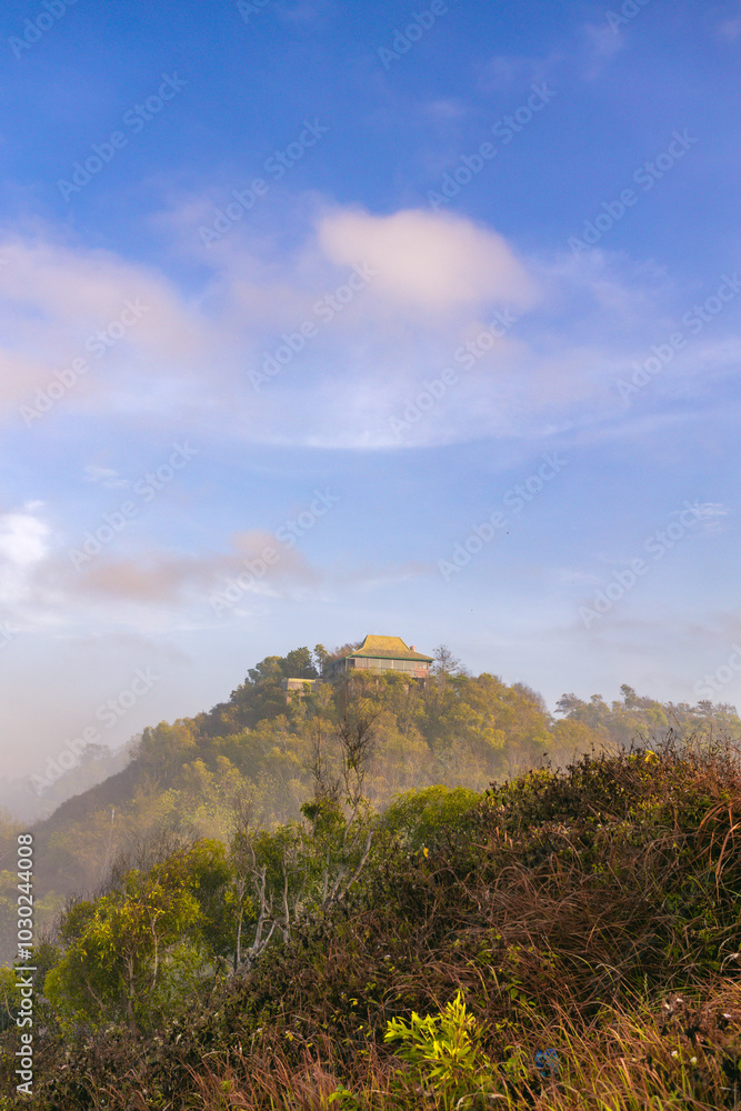 Fototapeta premium Breathtaking panoramic view of a hidden paradise, with rolling hills and a misty mountaintop.